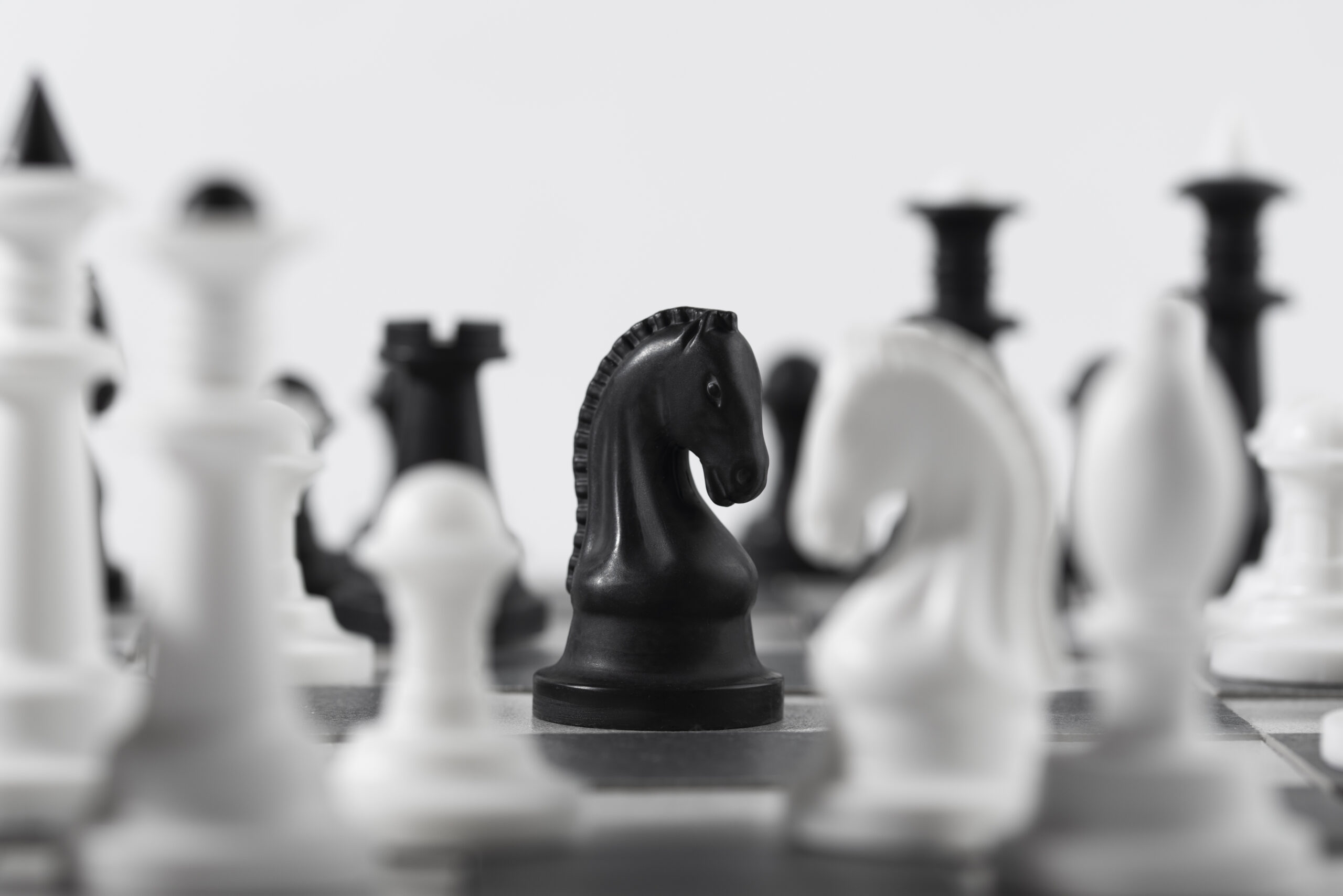 monochrome chess pieces with game board scaled